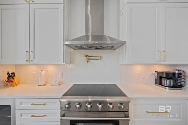 kitchen featuring white cabinetry, stainless steel electric range oven, and wall chimney range hood