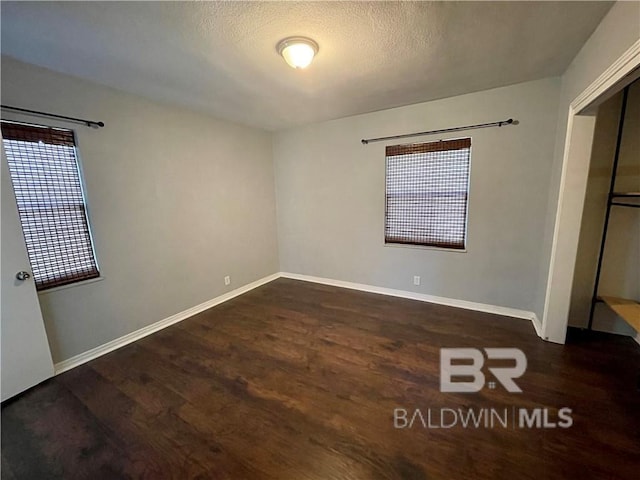 unfurnished bedroom featuring dark wood-type flooring and a textured ceiling