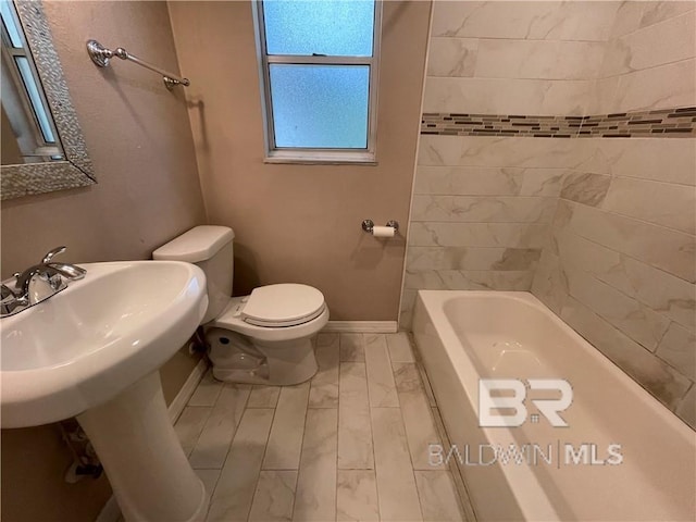 bathroom featuring toilet and tiled shower / bath combo