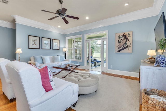 living area featuring light wood finished floors, visible vents, a ceiling fan, and ornamental molding
