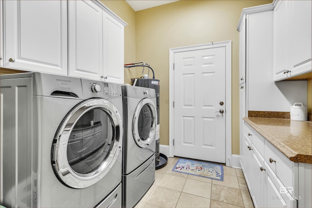 laundry room with baseboards, light tile patterned floors, cabinet space, and washer and clothes dryer