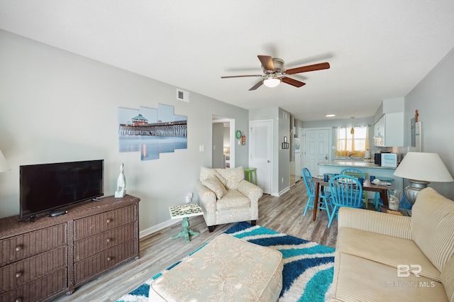 living room with ceiling fan and light hardwood / wood-style floors