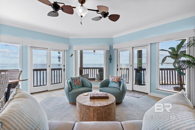 living area with tile patterned flooring, crown molding, and ceiling fan