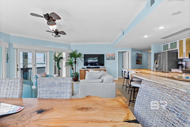 living room featuring ornamental molding, ceiling fan, baseboards, and recessed lighting