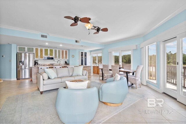 living area with light tile patterned flooring, ornamental molding, and ceiling fan