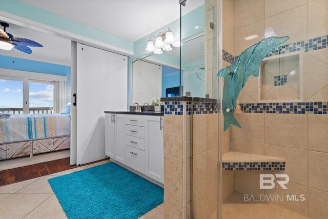 bathroom with ensuite bath, a shower stall, ceiling fan, vanity, and tile patterned flooring