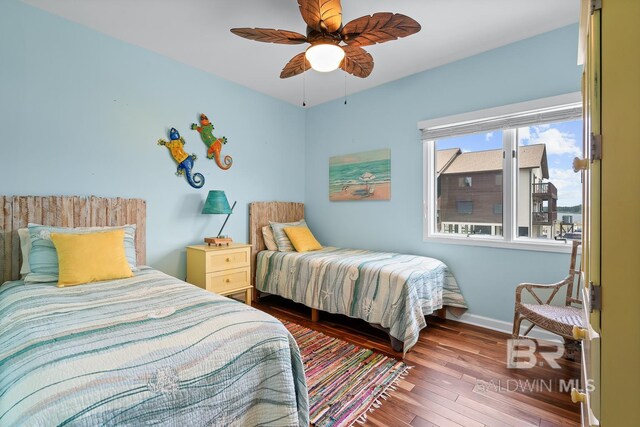bedroom with hardwood / wood-style flooring, baseboards, and a ceiling fan