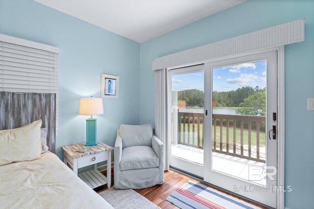bedroom with access to outside and wood finished floors
