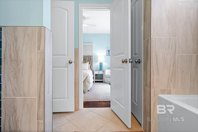 bathroom with tile patterned flooring and a tub to relax in