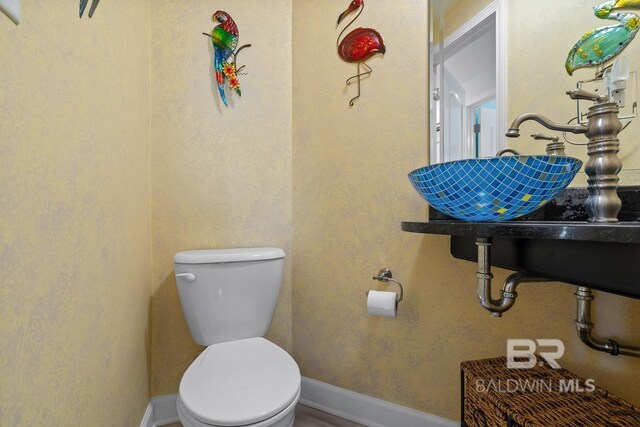 bathroom with toilet and baseboards