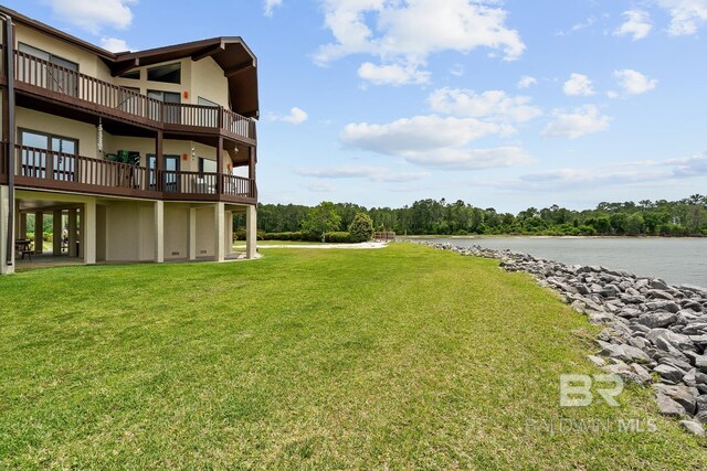 view of green lawn featuring a water view