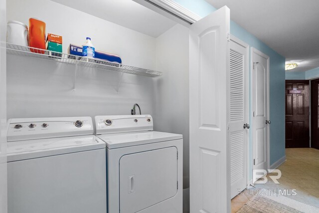 clothes washing area featuring separate washer and dryer and light tile patterned flooring