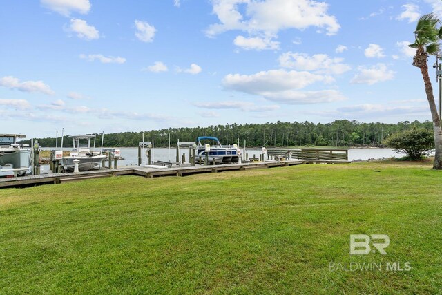 dock area with boat lift, a water view, and a lawn