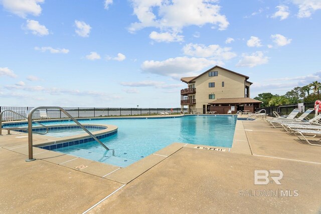 community pool with fence and a patio