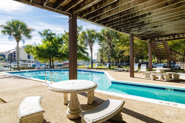 community pool featuring fence and a patio area