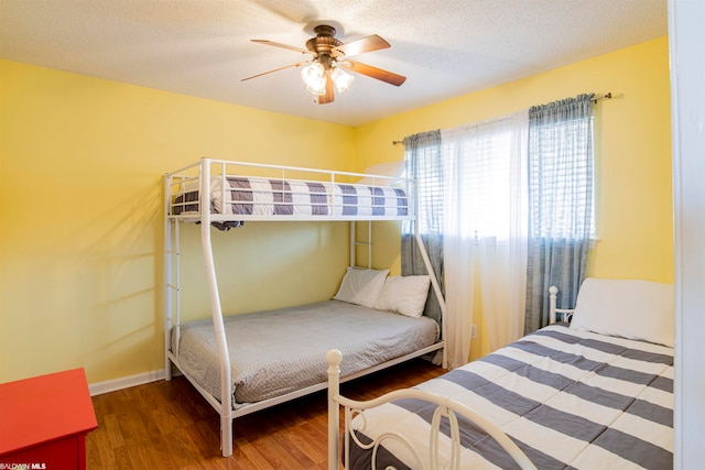 bedroom featuring ceiling fan, a textured ceiling, and dark wood-type flooring