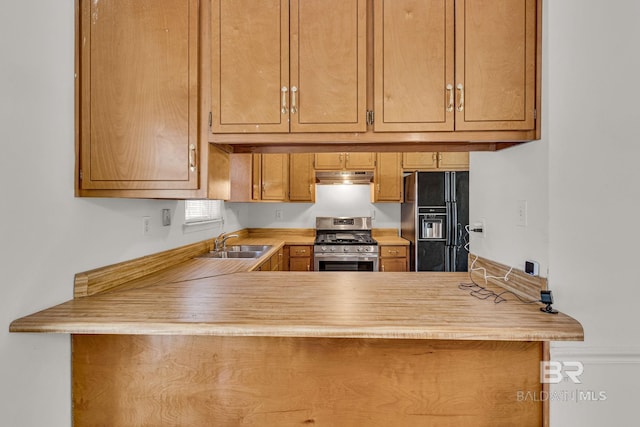 kitchen with sink, black fridge, and stainless steel gas range