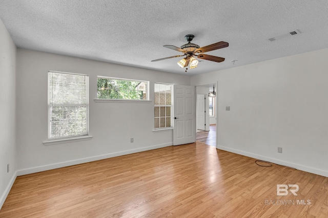 spare room featuring light wood-type flooring, a textured ceiling, and ceiling fan