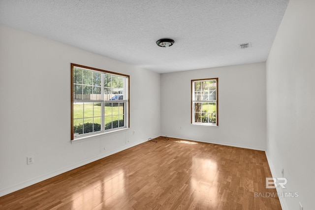 spare room with hardwood / wood-style flooring and a textured ceiling