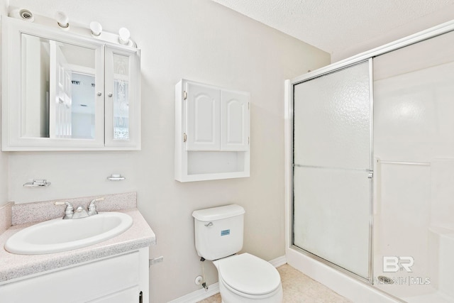 bathroom with a textured ceiling, vanity, toilet, and a shower with shower door