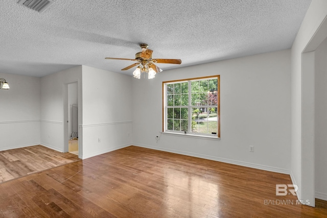 empty room featuring ceiling fan, hardwood / wood-style flooring, and a textured ceiling