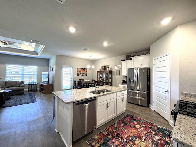 kitchen with white cabinets, dark wood-style flooring, stainless steel appliances, and a sink