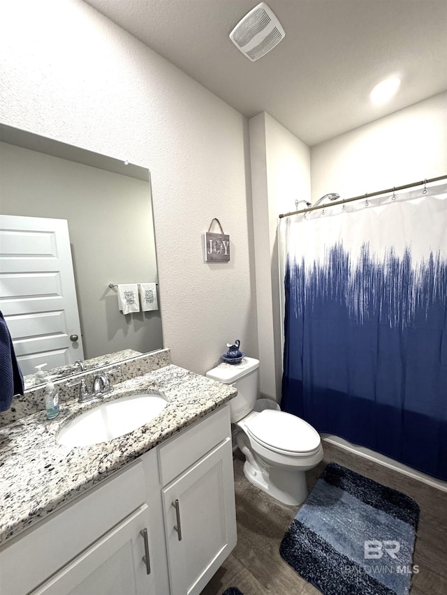 full bathroom featuring toilet, wood finished floors, vanity, visible vents, and a shower with curtain