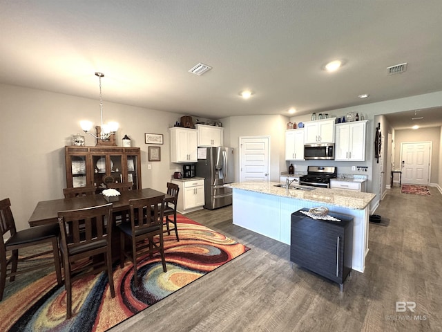 kitchen featuring stainless steel appliances, dark wood-type flooring, visible vents, and white cabinetry