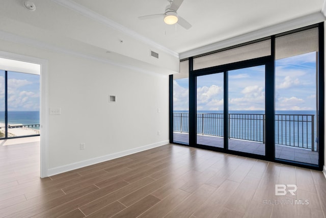 533 E Beach Blvd Unit 1905, Gulf Shores, AL 36542 - spare room featuring a water view, a wall of windows, wood finished floors, plenty of natural light, and a ceiling fan