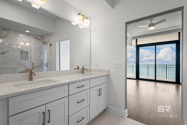533 E Beach Blvd Unit 1905, Gulf Shores, AL 36542 - bathroom with double vanity, expansive windows, a ceiling fan, a marble finish shower, and baseboards