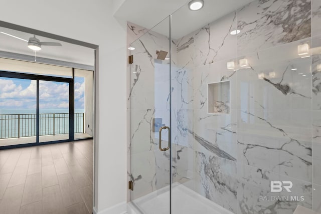 533 E Beach Blvd Unit 1905, Gulf Shores, AL 36542 - full bathroom with a marble finish shower, a water view, ceiling fan, and floor to ceiling windows