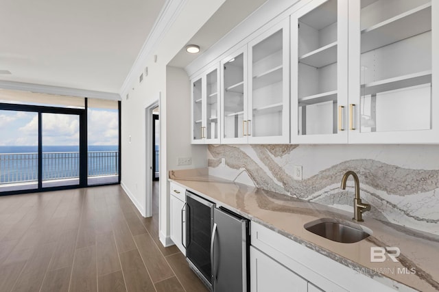 533 E Beach Blvd Unit 1905, Gulf Shores, AL 36542 - kitchen featuring a sink, expansive windows, beverage cooler, tasteful backsplash, and white cabinetry