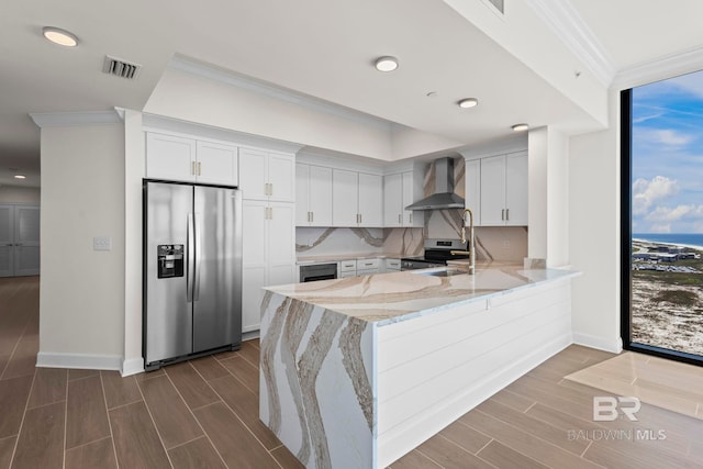 533 E Beach Blvd Unit 1905, Gulf Shores, AL 36542 - kitchen featuring stainless steel appliances, wall chimney range hood, ornamental molding, a peninsula, and wood finish floors