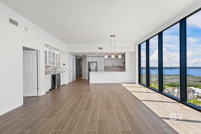 533 E Beach Blvd Unit 1905, Gulf Shores, AL 36542 - unfurnished living room featuring a water view, a wall of windows, dark wood finished floors, baseboards, and ornamental molding