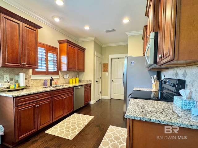 1030 Crown Walk Dr, Foley, AL 36535 - kitchen with stainless steel appliances, decorative backsplash, ornamental molding, dark wood finished floors, and light stone counters