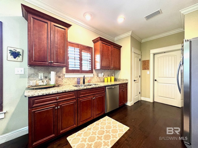 1030 Crown Walk Dr, Foley, AL 36535 - kitchen featuring appliances with stainless steel finishes, reddish brown cabinets, backsplash, dark wood-style flooring, and ornamental molding