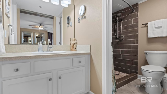 24132 Perdido Beach Blvd Unit 1011, Orange Beach, AL 36561 - full bathroom featuring toilet, a tile shower, tile patterned floors, vanity, and ceiling fan