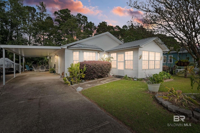 view of front of house with a carport and a lawn