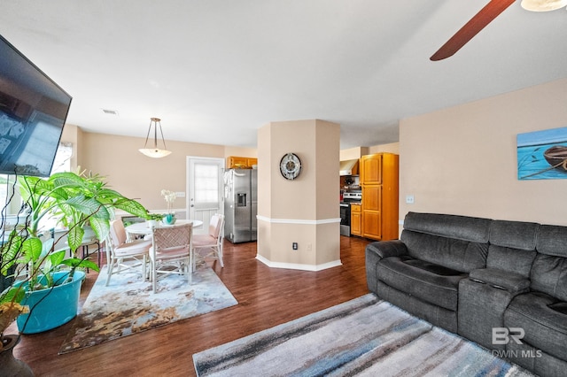 living room featuring dark hardwood / wood-style flooring and ceiling fan