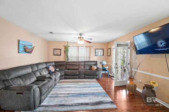 living room with ceiling fan and dark wood-type flooring