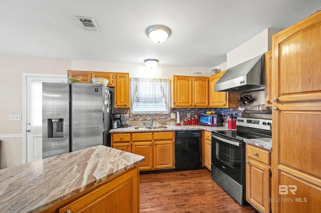 kitchen with decorative backsplash, dark wood-type flooring, exhaust hood, sink, and black appliances