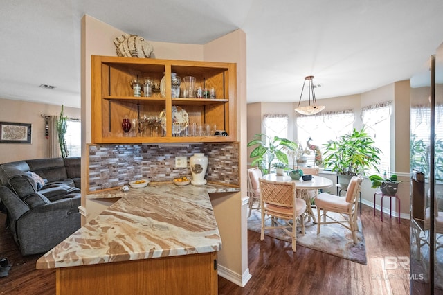 kitchen with pendant lighting, plenty of natural light, dark hardwood / wood-style floors, and kitchen peninsula