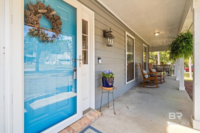 view of exterior entry featuring covered porch