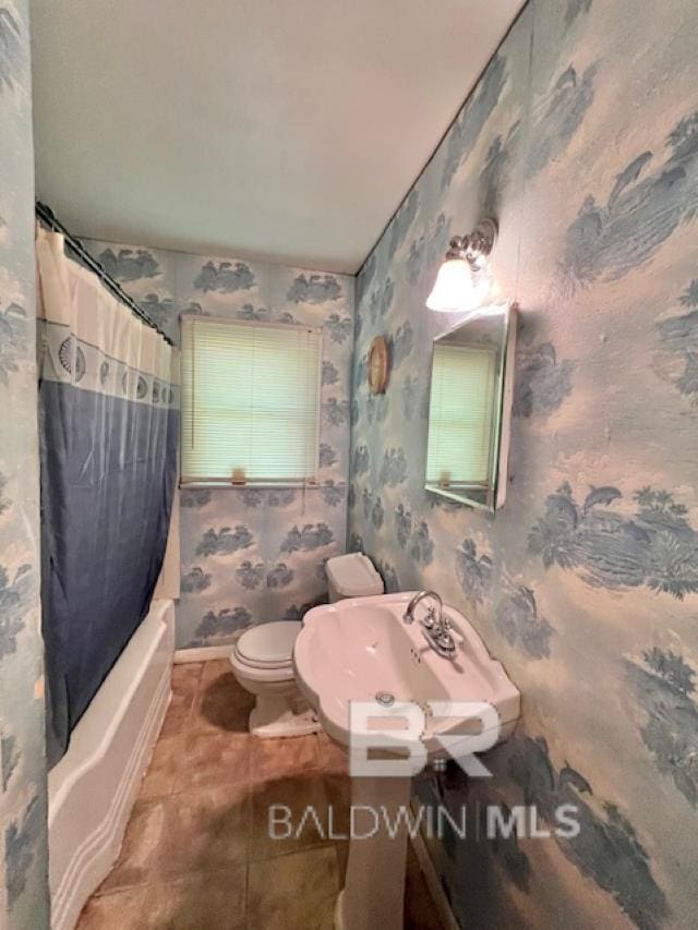 507 E Pine St, Atmore, AL 36502 - bathroom featuring tile patterned flooring, shower / tub combo, toilet, wallpapered walls, and a sink