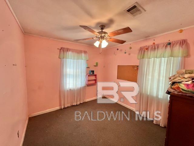 507 E Pine St, Atmore, AL 36502 - unfurnished bedroom with multiple windows, crown molding, baseboards, and visible vents
