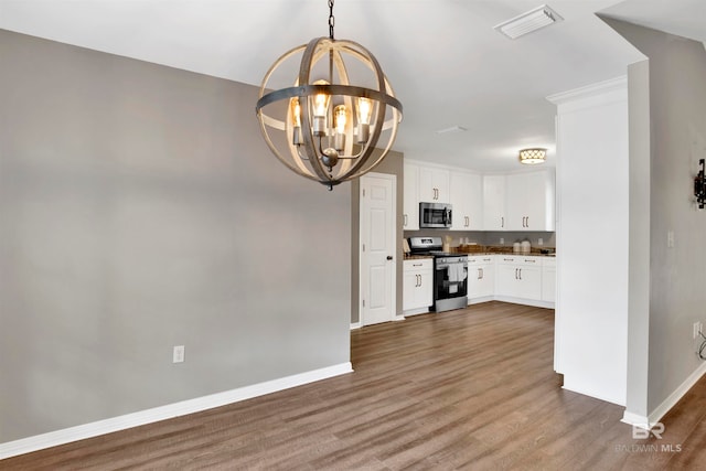 kitchen featuring pendant lighting, white cabinetry, wood-type flooring, and stainless steel appliances