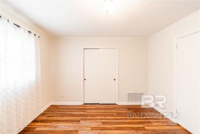 unfurnished room featuring ornamental molding and light hardwood / wood-style flooring