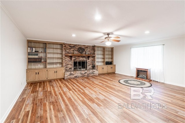 unfurnished living room featuring crown molding, a fireplace, ceiling fan, and light hardwood / wood-style floors