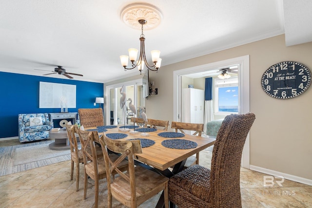 dining room featuring ceiling fan with notable chandelier, ornamental molding, light tile patterned floors, and baseboards