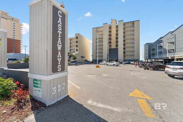 view of building exterior featuring uncovered parking and a city view